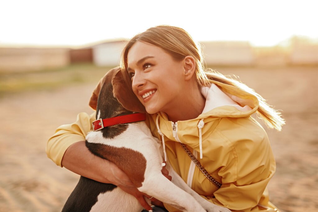 cheerful-lady-hugging-dog-and-smiling